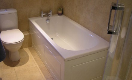 New bath with Nabis Nero taps, solid bath panels and natural tiles